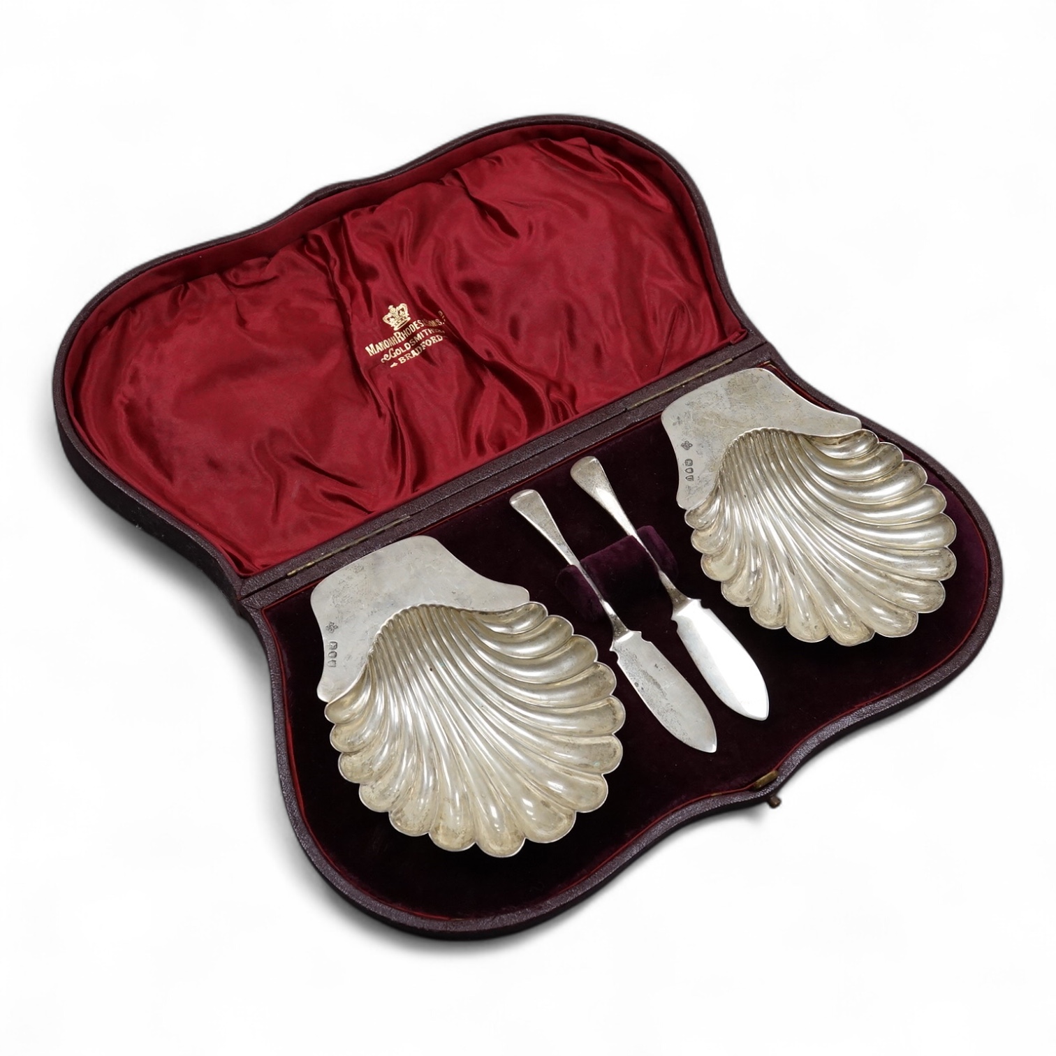 A late Victorian cased pair of silver butter shells and matching butter knives, by Horace Woodward & Co Ltd, London, 1894/5, shell 12.9cm, 5.6oz.